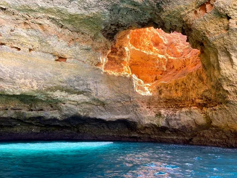 Lucarne dorée à l'intérieur de l'Algar de Benagil vue depuis l'excursion en bateau rapide
