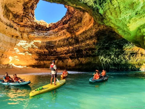 Guide leading a Benagil Caves kayak tour toward the cave entrance