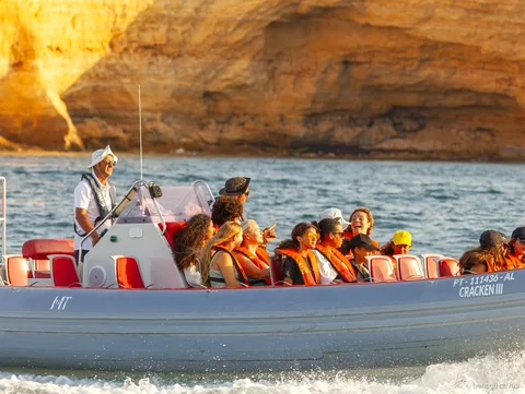 Pasajeros con chaleco salvavidas en la excursión en lancha rápida a las Cuevas de Benagil